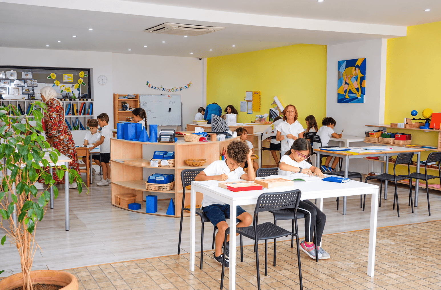 Children working at tables in a bright classroom