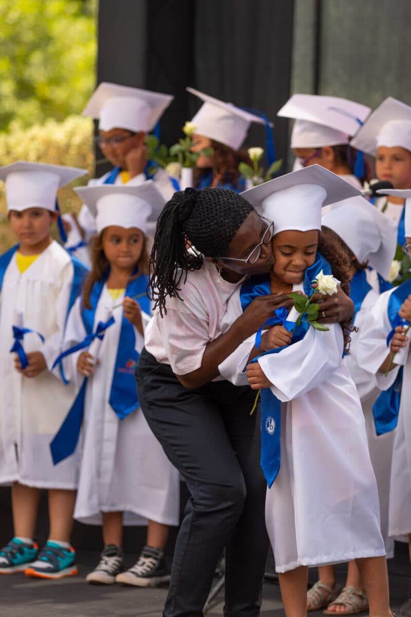Young graduates celebrating with their teacher