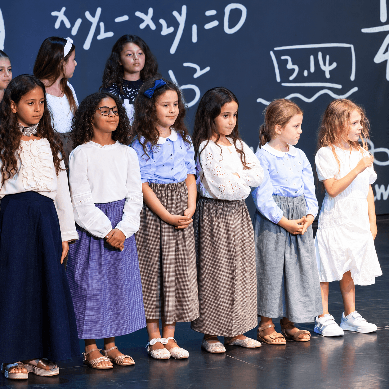 Elementary learners standing together on stage during a school performance