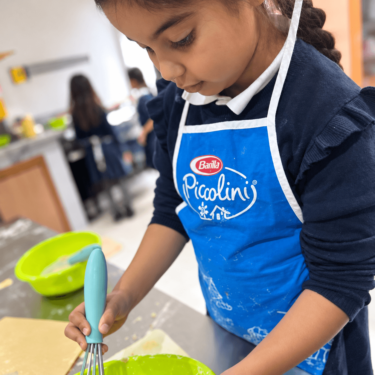 A young chef whisking ingredients in a cooking class