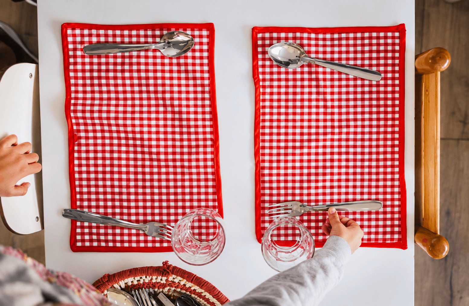 Children setting the table with placemats, cutlery and glasses