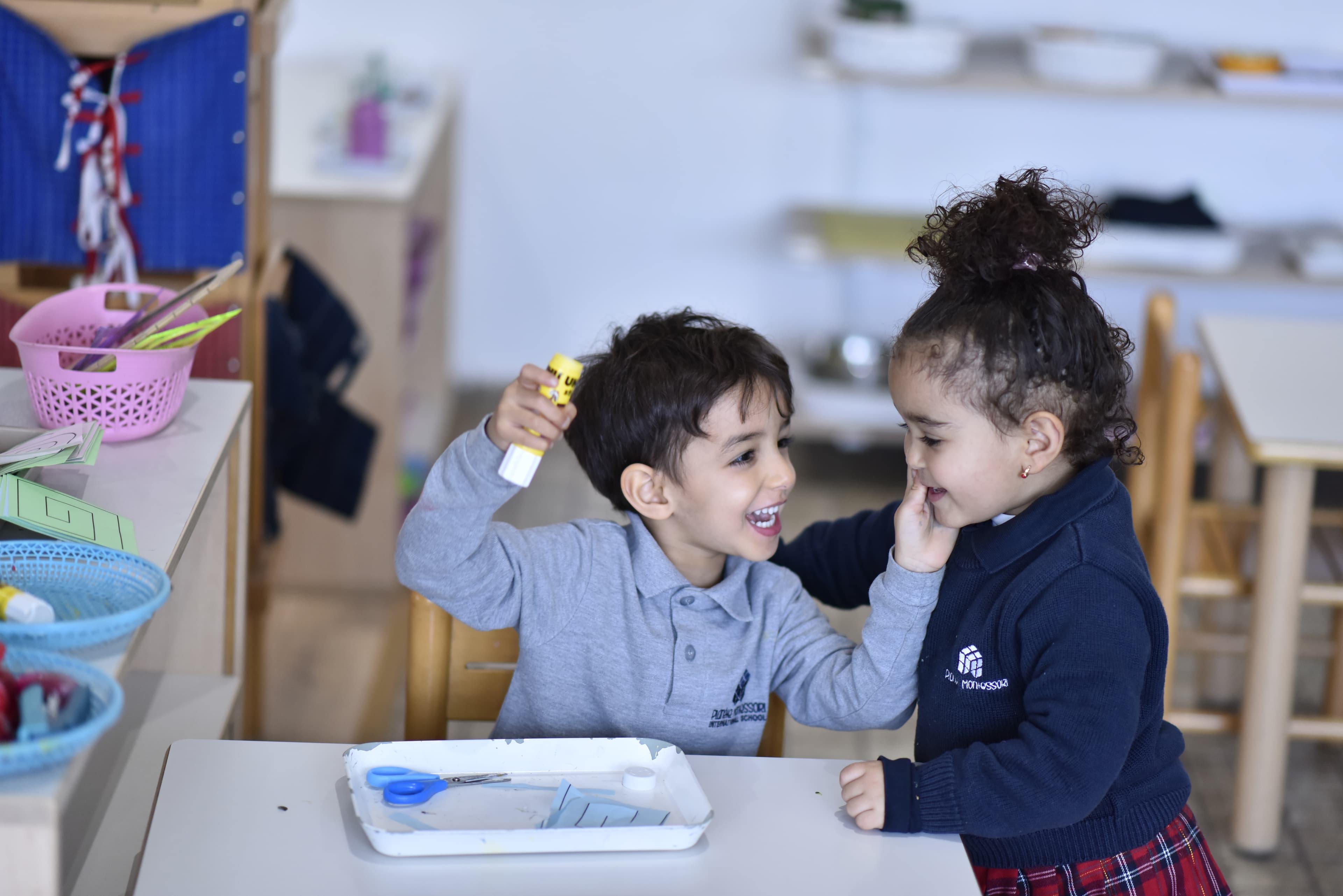 Two Planète Montessori pupils reading a book together outdoors