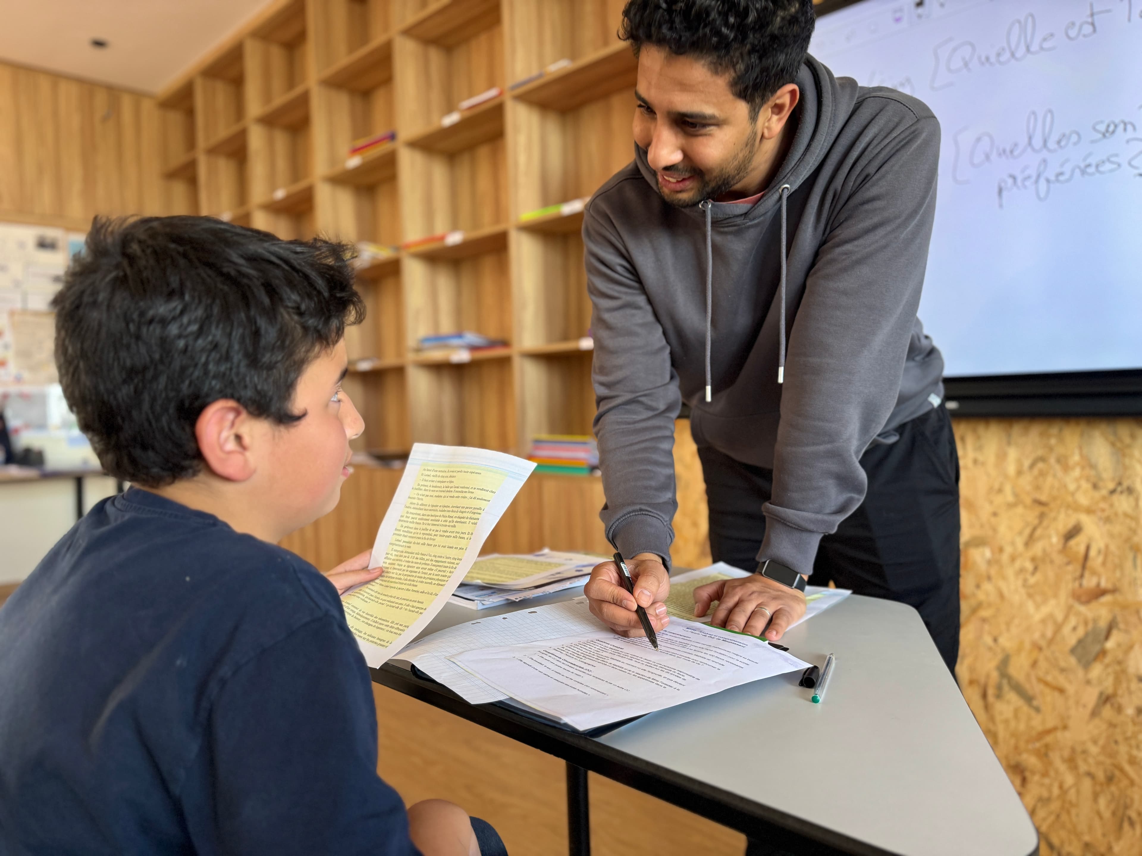 A guide working one-to-one with a learner in a Montessori classroom